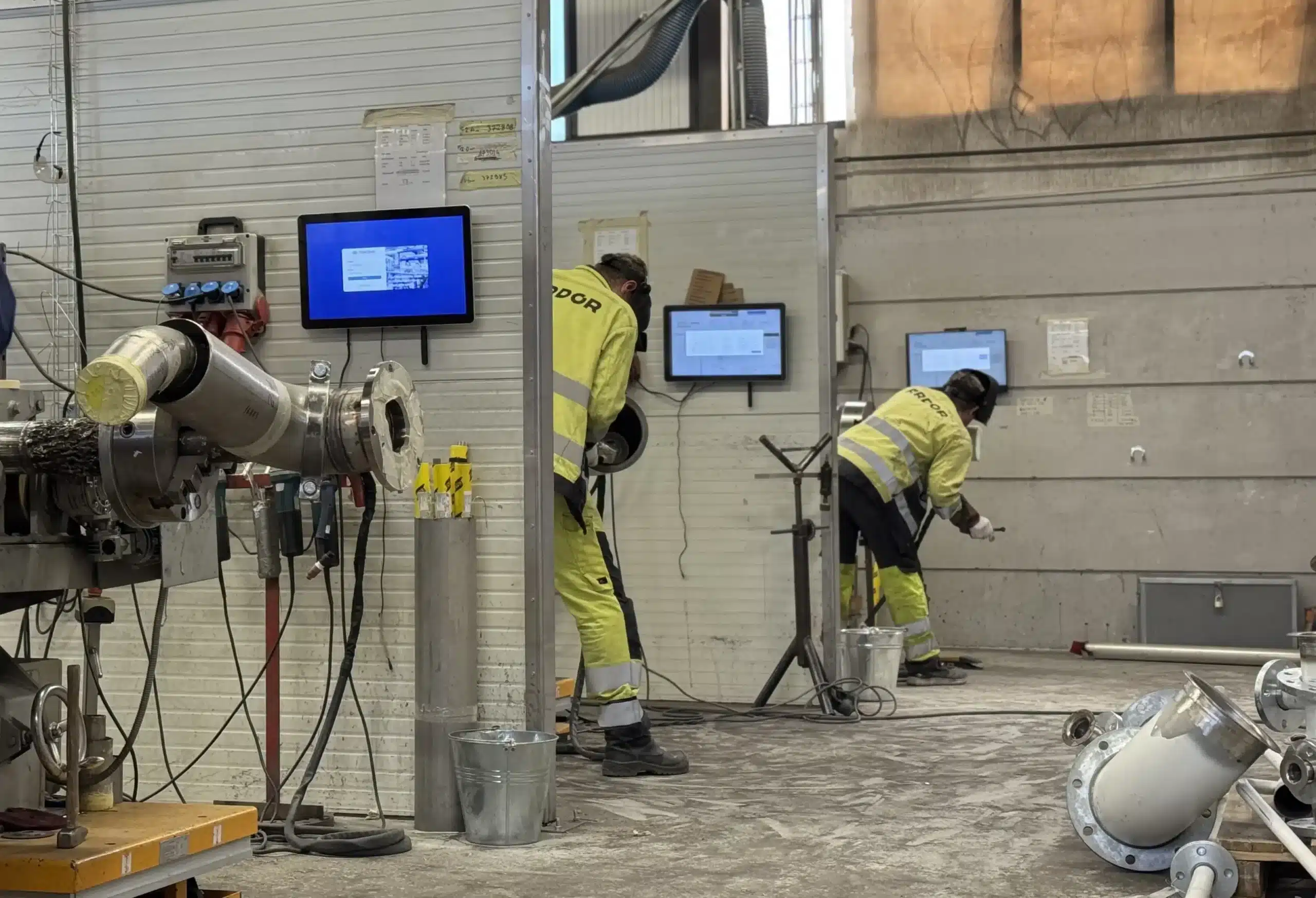PipeCloud at the shop floor, with people working on spools having a screen with PipeCloud in front of them.